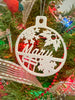 A white circular christmas tree ornament in a tree that says Mary and has snow flake, holly, and a present.