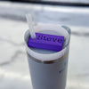 A purple name plate with black lettering that says john on top of a 20 or 30oz stanley tumbler