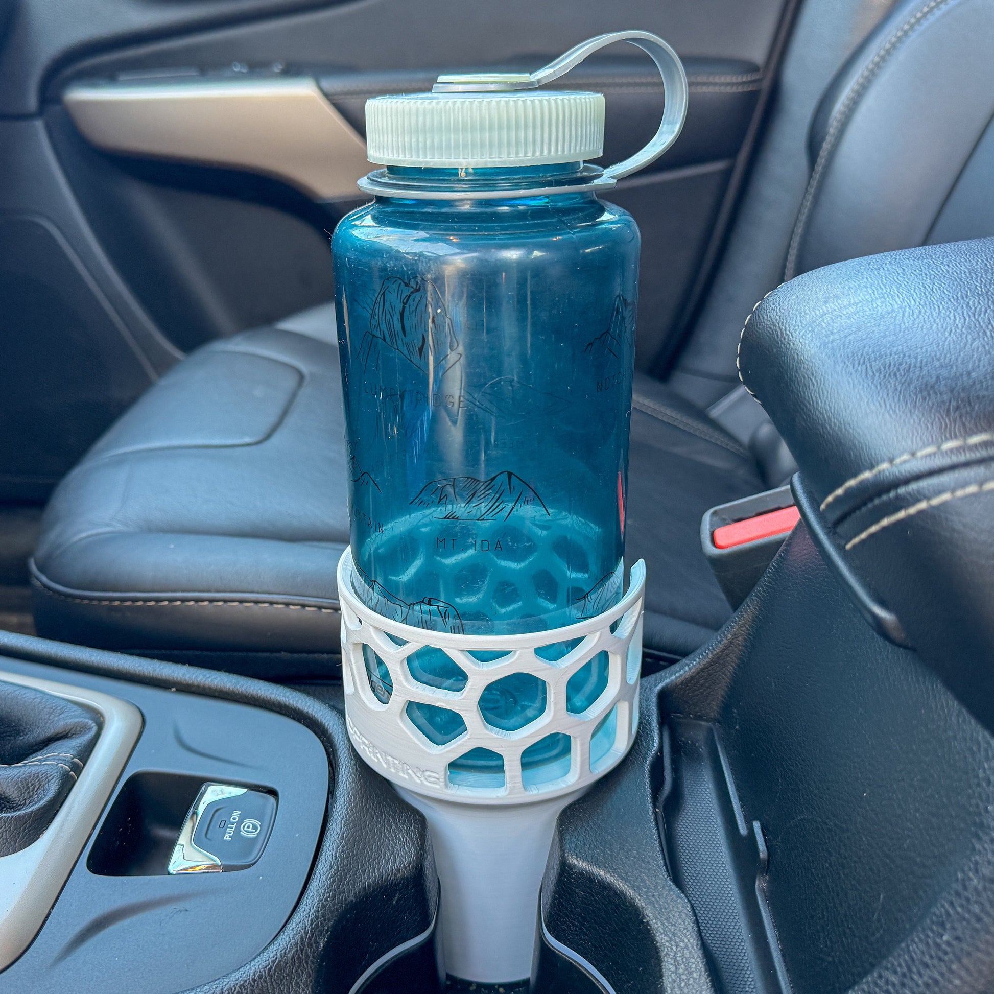 A white car cup holder adapter holding a 32 oz nalgene water bottle