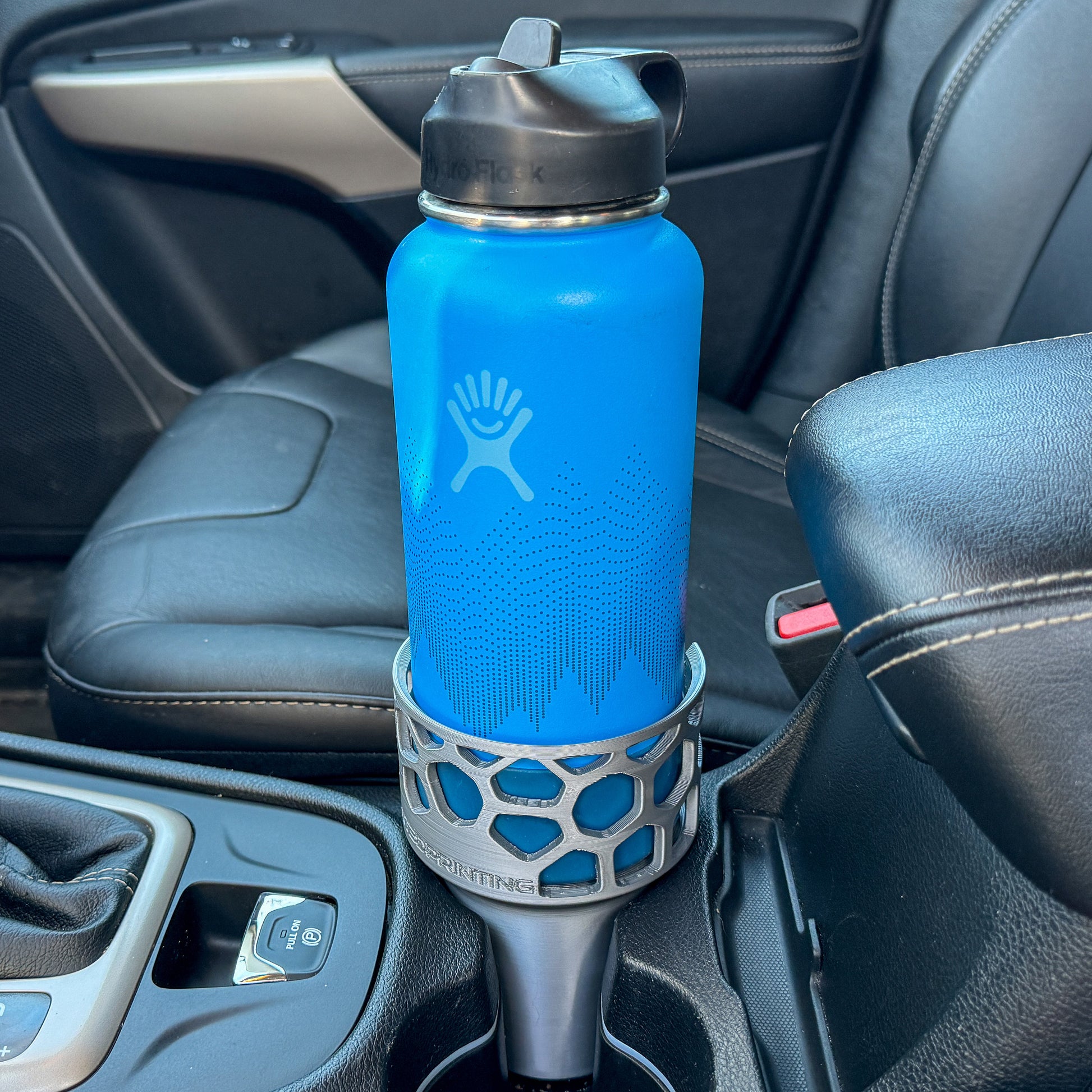 A grey car cup holder adapter holding a 32 oz hydro flask water bottle